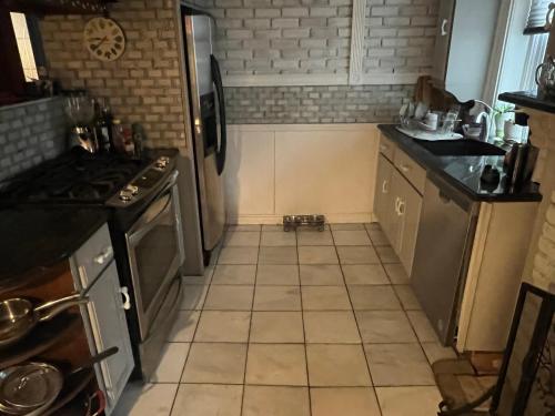 a kitchen with a refrigerator and a tiled floor at 2 Br Victorian Apt 2800 sq ft 2 floors with Full Kitchen 2 baths and Laundry in Poughkeepsie