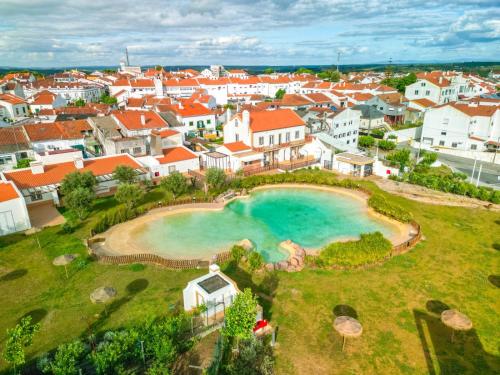 an aerial view of a town with a swimming pool at São João Alojamento in Gavião