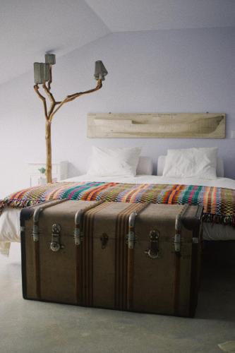 a suitcase sitting on the floor next to a bed at Casa Oliva - Casa da Mata in Porto de Mós