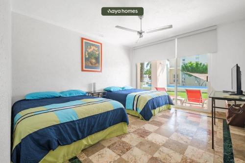 a bedroom with two beds and a desk and a television at Amazing House with Private Pool - Tennis & Paddle Court in Acapulco