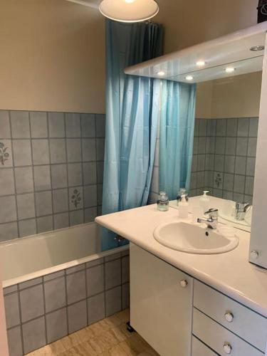 une salle de bain avec un lavabo, une baignoire et un miroir dans l'établissement Biarritz studio extra centre grande plage, à Biarritz