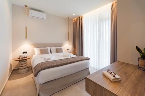 a bedroom with a large white bed and a table at Ioannina Secret Luxury Villas in Ioannina