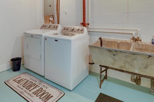 uma cozinha com uma máquina de lavar roupa e um lavatório em Lake Michigan Getaway Walk to Beach and Golf! em Muskegon