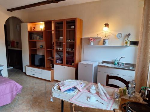 a room with a table and a kitchen with a sink at B&B Bertaina Mauro in Cavallermaggiore