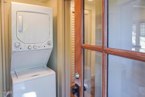 uma lavandaria com uma máquina de lavar e secar roupa ao lado de uma porta em 1940 Cottage on the Nature Coast em Yankeetown