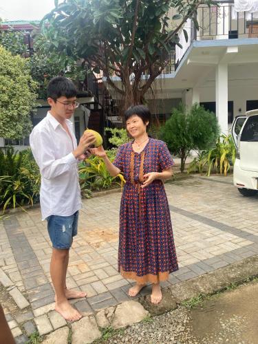 a man standing next to a woman holding a banana at Hotel Siyathma polonnaruwa in Polonnaruwa