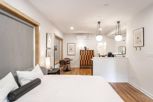 a bedroom with a white bed and a kitchen at Steps to Bathhouses, Historic Studio, KING BED, Room # 101 in Hot Springs