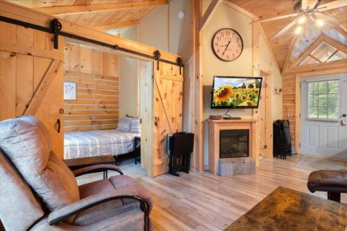 ein Wohnzimmer mit Kamin, Bett und Uhr in der Unterkunft The Eldon Cabin Experience in Eldon