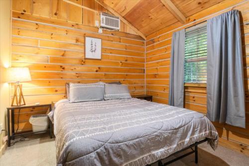 ein Schlafzimmer mit einem Bett in einer Blockhütte in der Unterkunft The Eldon Cabin Experience in Eldon