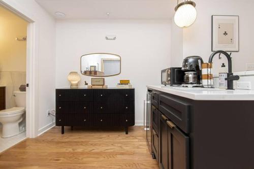 y baño con lavabo y tocador con espejo. en Steps to Bathhouses, Historic Studio, KING BED, Room # 101, en Hot Springs