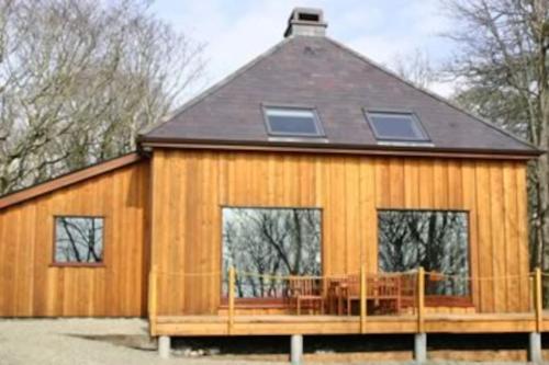 a large wooden house with a deck and windows at The Foresters House in Creagh