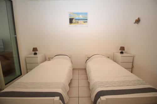 deux lits dans une petite pièce avec un miroir dans l'établissement maison 6 personnes proche de la plage, à Canet