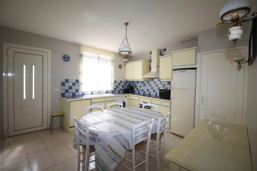 une cuisine avec une table et des chaises dans l'établissement maison 6 personnes proche de la plage, à Canet