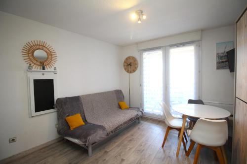 un salon avec un canapé et une table dans l'établissement studio pour 4 vue marina, à Canet