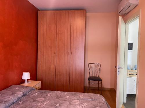 a bedroom with a bed and a chair and a cabinet at Borgo DiVino in Alba