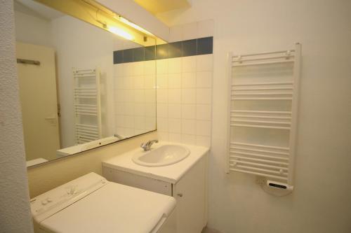 une salle de bain blanche avec un lavabo et un miroir dans l'établissement studio pour 4 vue marina, à Canet