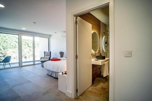 a bedroom with a bed and a desk and a window at Pachán Dehesa Boyal in Cuenca