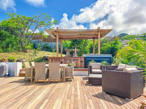 a patio with a table and chairs and a grill at Villa Marguerite private pool and hot tub in Orient Bay in Orient Bay