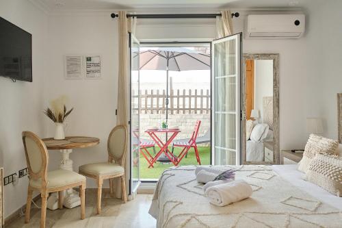 sypialnia z łóżkiem i stołem oraz patio w obiekcie Studio Novena Little Apartments w Kadyksie