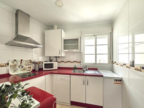 cocina con armarios blancos y encimera roja en Studio Novena Little Apartments, en Cádiz