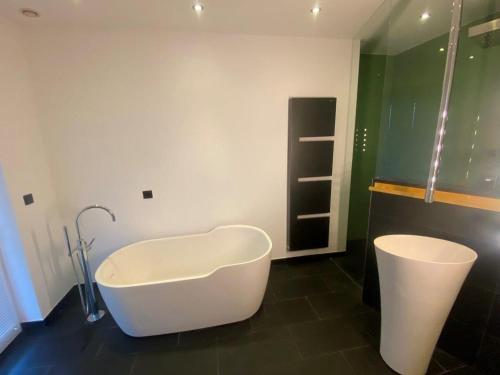 a bathroom with a bath tub and a sink at Penthouse Langenloiserberg in Krems an der Donau