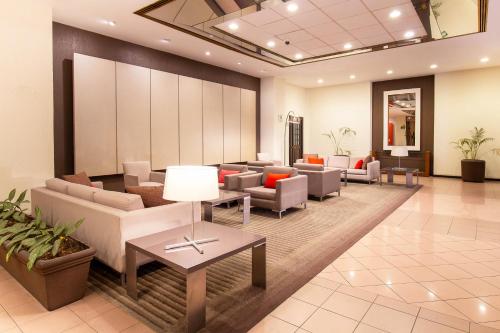 a waiting room with couches and tables in a lobby at Hotel Guadalajara Plaza Expo in Guadalajara