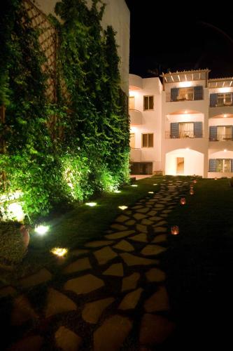 a building with lights on the side of a sidewalk at Oasis Beach Hotel in Skala