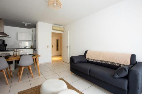 un salon avec un canapé bleu et une cuisine dans l'établissement Appartement Antibéa - Welkeys, à Antibes