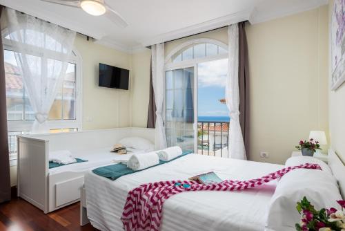 アデへにあるVilla Marzella - Costa Adejeの大きな窓付きの客室で、ベッド2台が備わります。