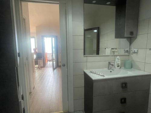 La salle de bains est pourvue d'un lavabo et d'un miroir. dans l'établissement DOMO A MARE, à Magomadas