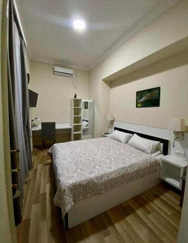 - une chambre avec un grand lit et un bureau dans l'établissement Apartment on Vera, à Tbilissi