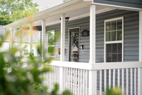 a front porch of a house with a white fence at Bluewater Downtown Cottage in Wilmington