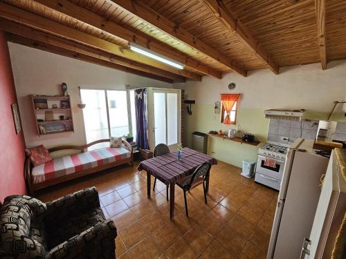 a kitchen and living room with a table and a couch at Dpto BBB in Zapala