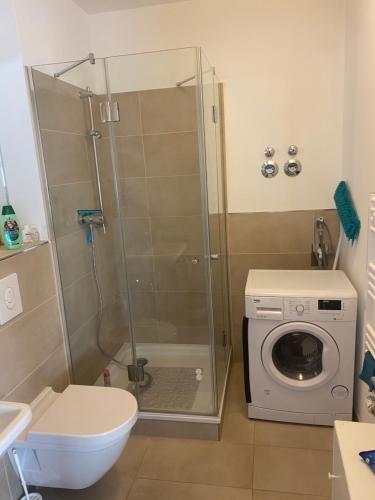 ein Badezimmer mit Dusche und Waschmaschine in der Unterkunft Appartement Havelblick in Berlin