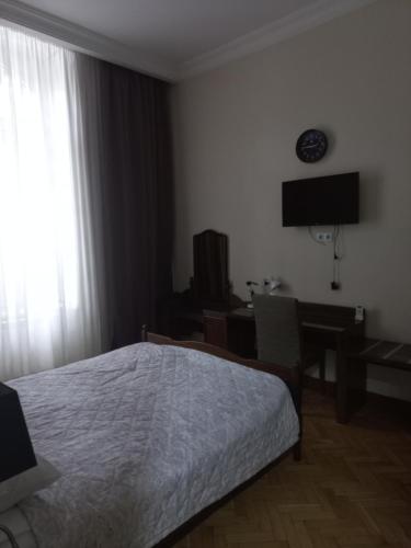 - une chambre avec un lit, un bureau et une fenêtre dans l'établissement Apartment on Vera, à Tbilissi