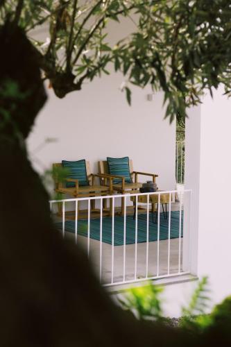 two chairs with blue cushions sitting on a balcony at Casa Oliva - Casa da Serra in Porto de Mós