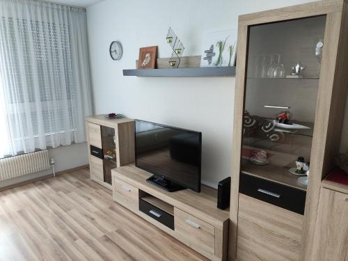 a living room with a flat screen tv in a wooden entertainment center at HOG Apartment Nürnberg St. Peter in Nuremberg