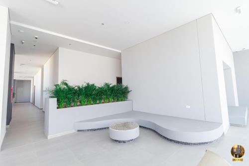 een witte bank in een kamer met planten aan de muur bij Hermoso Apartamento tipo Loft en Rodadero Santa Marta in Santa Marta
