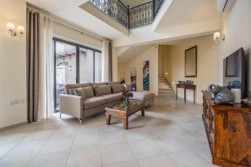a living room with a couch and a table at Poolside Paradise Villa Zebbug in Żebbuġ