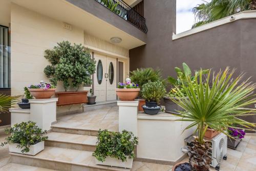 a bunch of potted plants on a house at Poolside Paradise Villa Zebbug in Żebbuġ