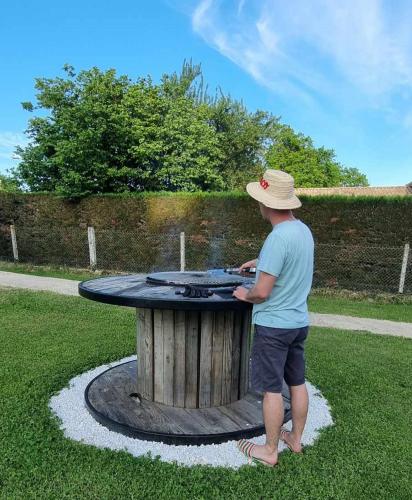a man in a hat standing next to a table at Gite Le Cocon de Lily in Saint-Savin-de-Blay