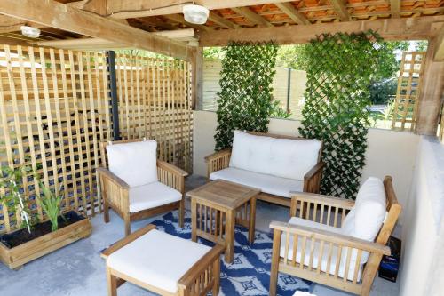 a patio with two chairs and a table and benches at Gite Le Cocon de Lily in Saint-Savin-de-Blay