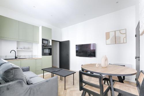 un salon avec un canapé et une table dans l'établissement Mogador - Opéra Haussmann Charming Apartment 4P 1BDR, à Paris