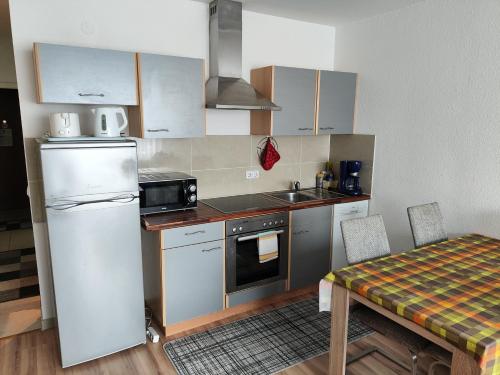 een kleine keuken met een witte koelkast en een tafel bij HOG Apartment Nürnberg St. Peter in Neurenberg