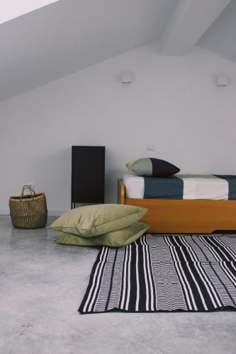 a bedroom with a bed and a rug at Casa Oliva - Casa da Serra in Porto de Mós