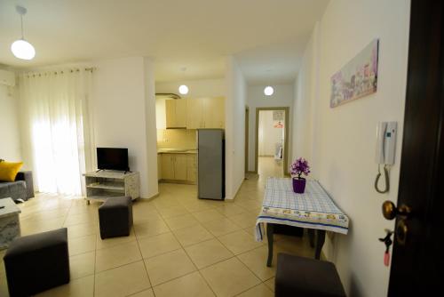 a living room with a table and a kitchen at Harris&Arvien Apartment's in Vlorë