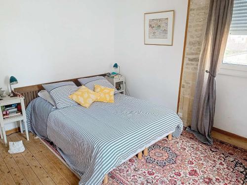 une chambre avec un lit avec une couverture rayée bleue et blanche dans l'établissement Charmante Villa en Pierre, Proche Plage, Cheminée, Cuisine Équipée, Jardin Clos, Expo Sud - FR-1-746-20, à Langrune-sur-Mer