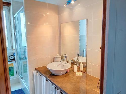 une salle de bain avec deux lavabos et un grand miroir dans l'établissement Charmante Villa en Pierre, Proche Plage, Cheminée, Cuisine Équipée, Jardin Clos, Expo Sud - FR-1-746-20, à Langrune-sur-Mer