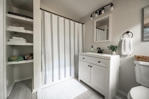 La salle de bains est pourvue d'un lavabo blanc et d'un miroir. dans l'établissement Bluewater Downtown Cottage, à Wilmington