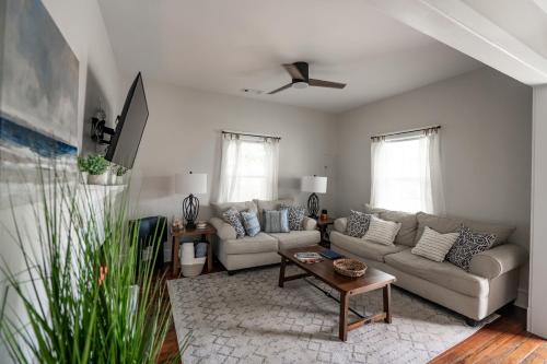 a living room with two couches and a table at Bluewater Downtown Cottage in Wilmington